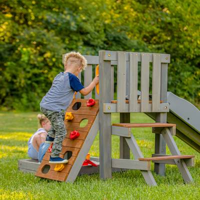 Toddlers climbing on mini playset